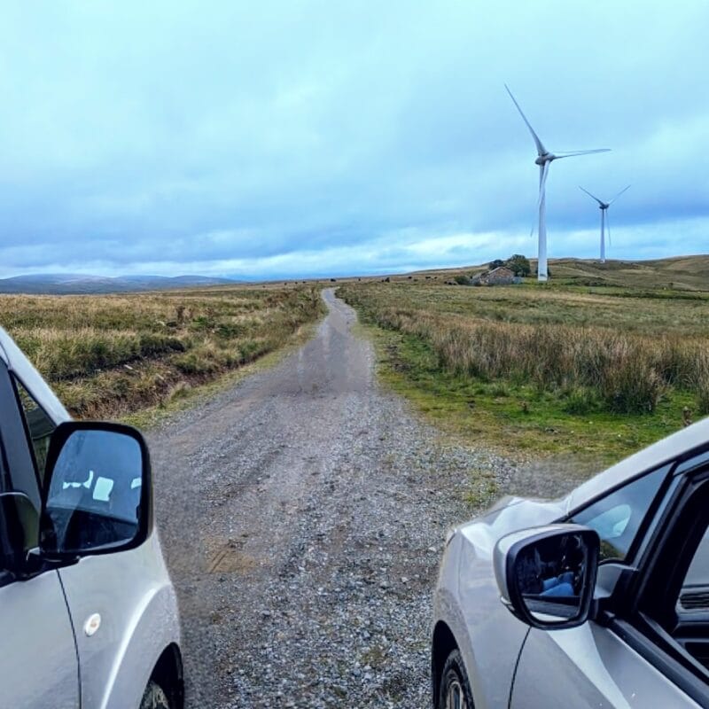 Two cars by the wind farm