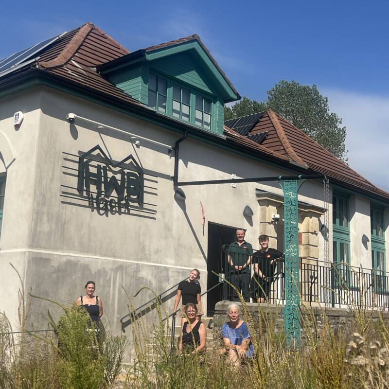 a group of people standing outside Hwb y Gors in the sunshine
